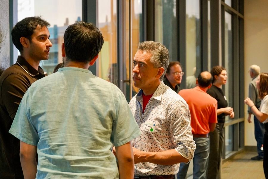 Dr. Fernando Pérez in conversation with attendees by the windows