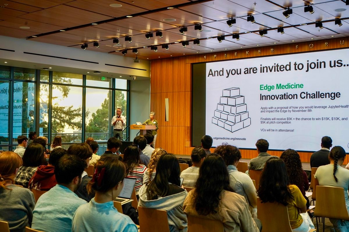 Dr. Fernando Pérez and Dr. Ida Sim on stage beside the &ldquo;And you are invited to join us&hellip; Edge Medicine Innovation Challenge&rdquo; slide
