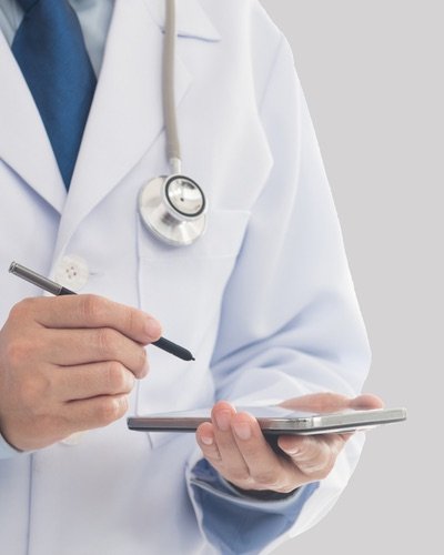 Doctor in a white coat reviewing a tablet